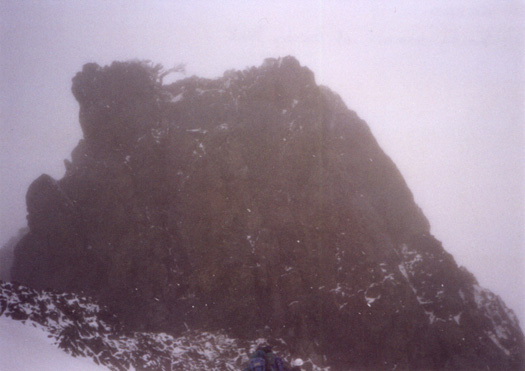 Summit pyramid of Unicron peak, shrouded in blowing snow